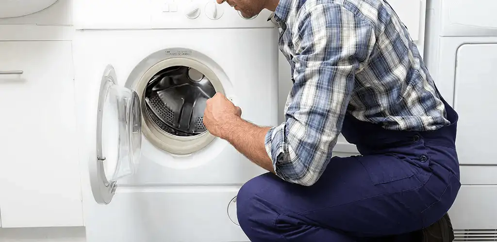 Handyman inspecting a dryer drum and internal parts for repair in Syracuse, NY