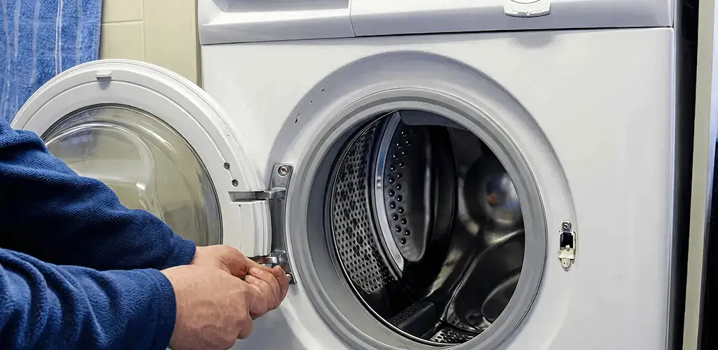 Washing machine repair handyman checking a front-load washer door and latch in Syracuse, NY