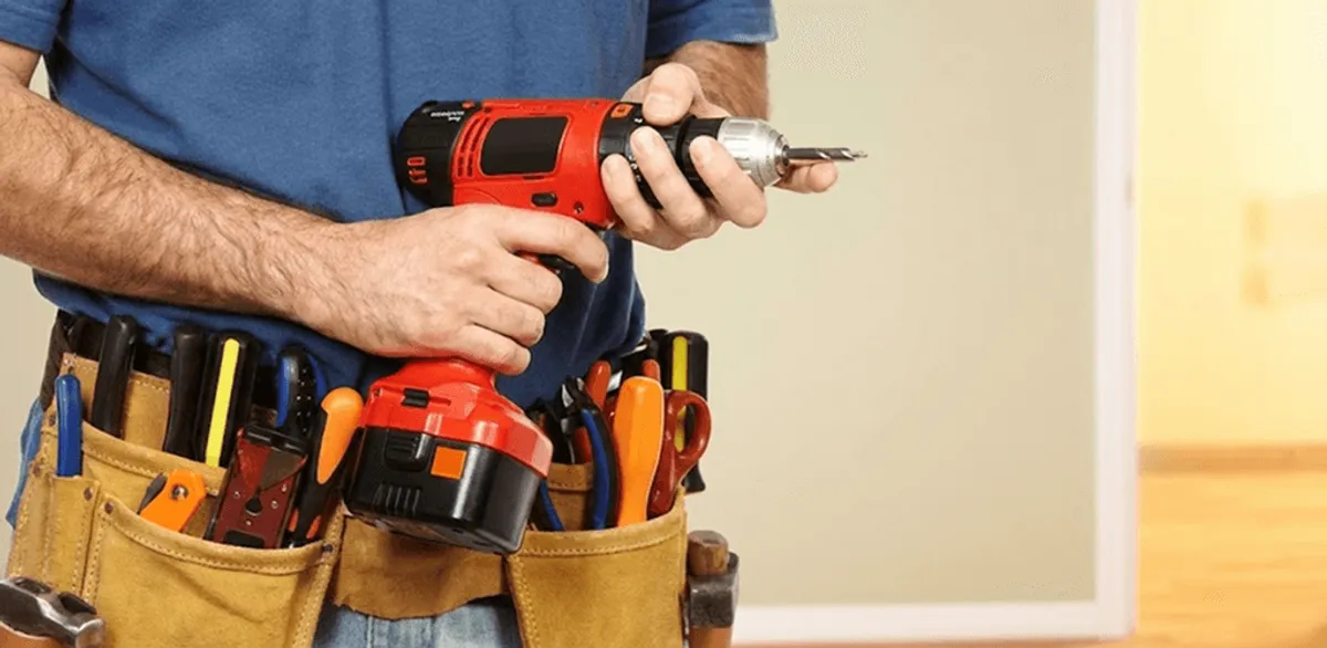 Handyman holding a power drill for home repairs and installations in Syracuse, NY