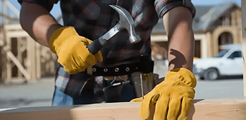 Handyman fixing wood trim with a hammer for home repairs in Syracuse, NY